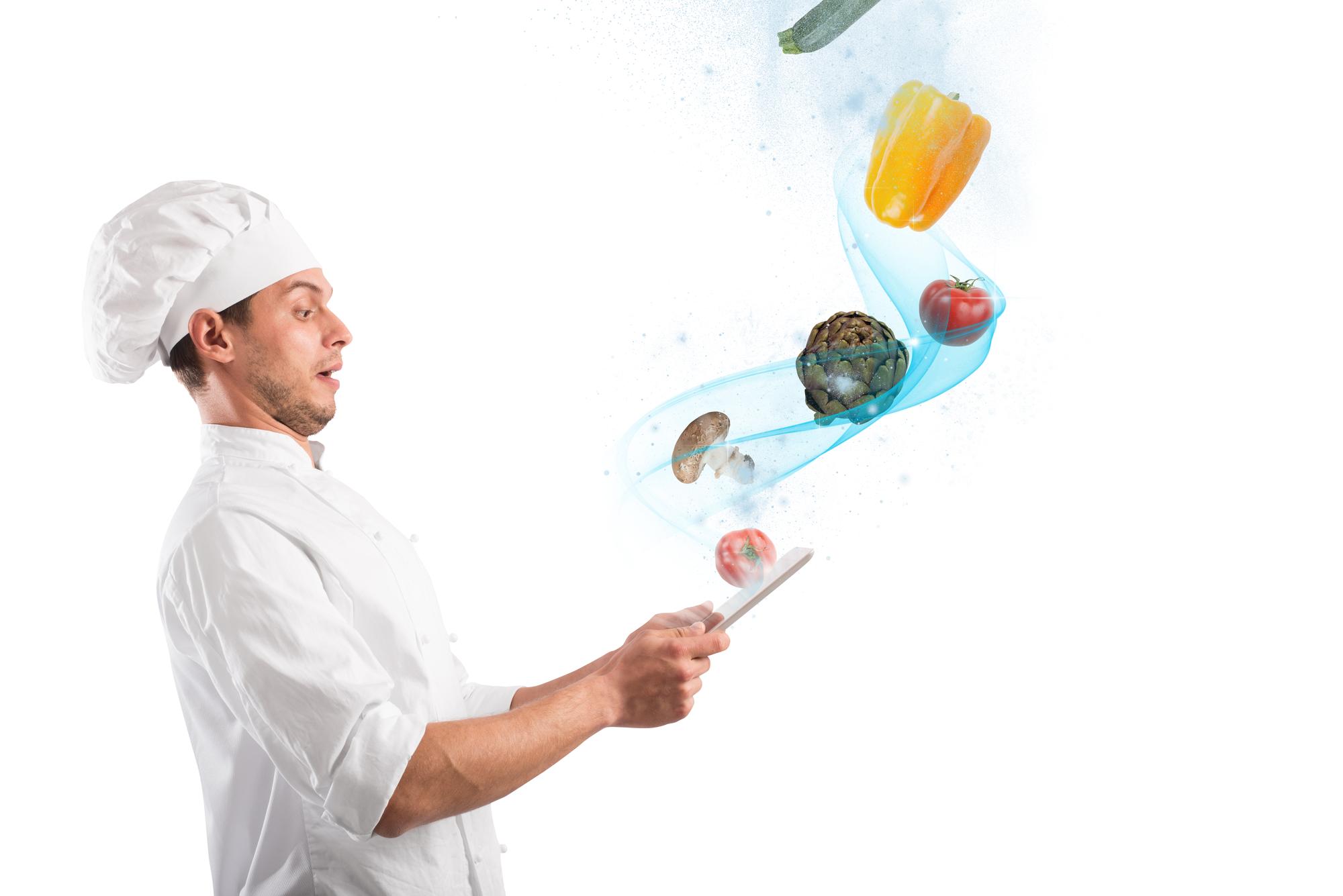 Chef moderno che cucina con dispositivi tecnologici